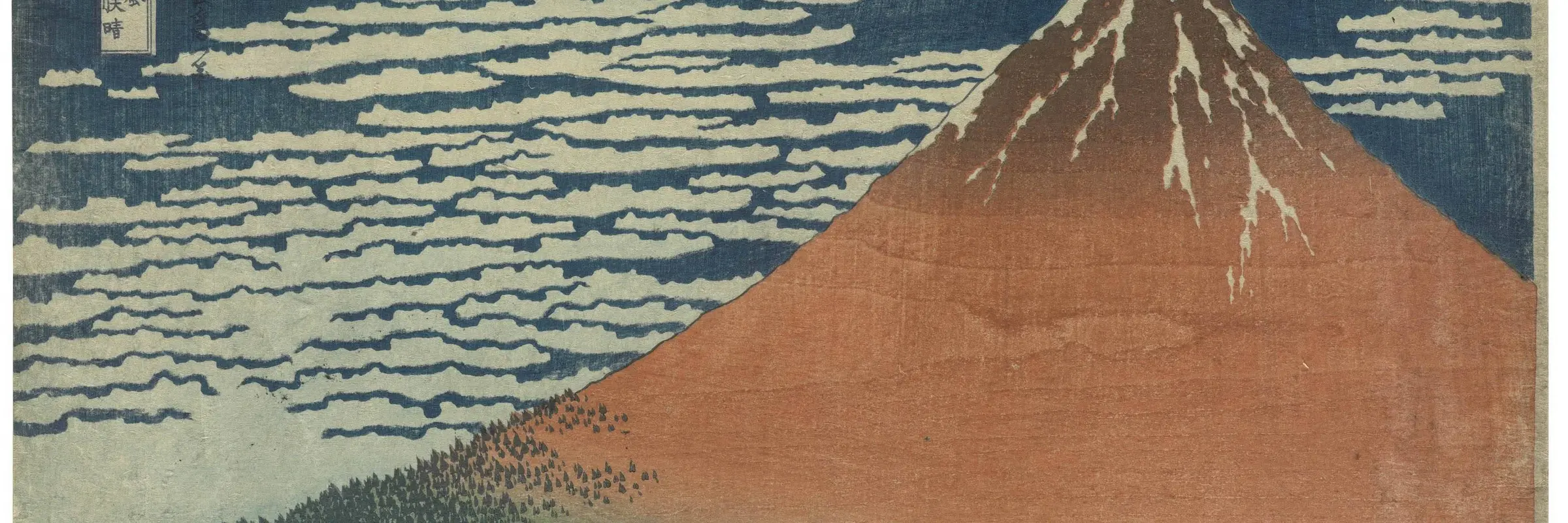 Roter Berg vor blauem Himmel mit weißem Wind.