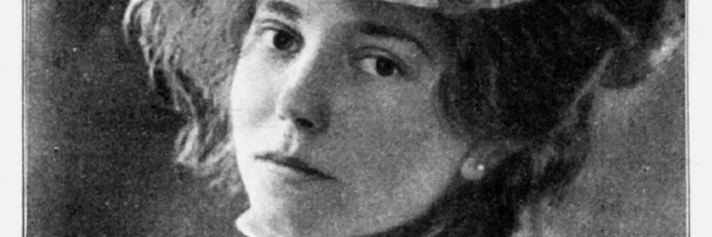 Ein schwarz-weißes Bild einer Frau mit blumenbestecktem Hut